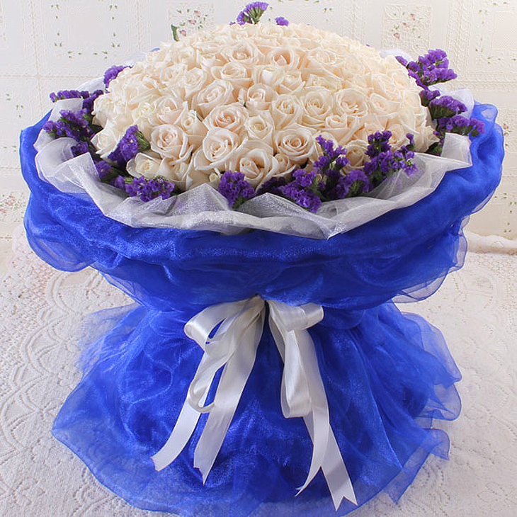【花  材】  99朵白玫瑰,勿忘我外围,蓝色和白色软纱包裹白色卷边纸
